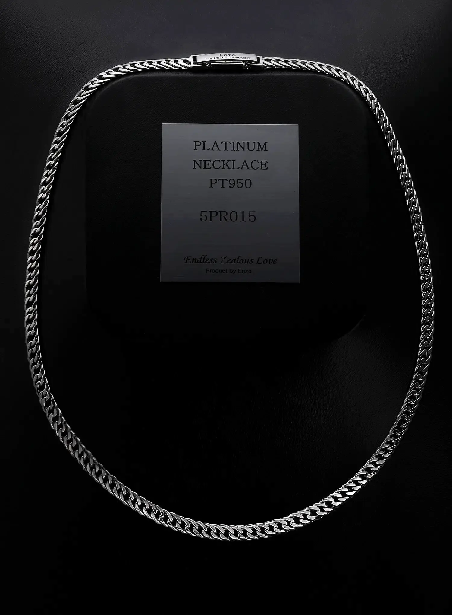 A 7mm men's platinum cuban chain necklace with engraving on the clasp in black background