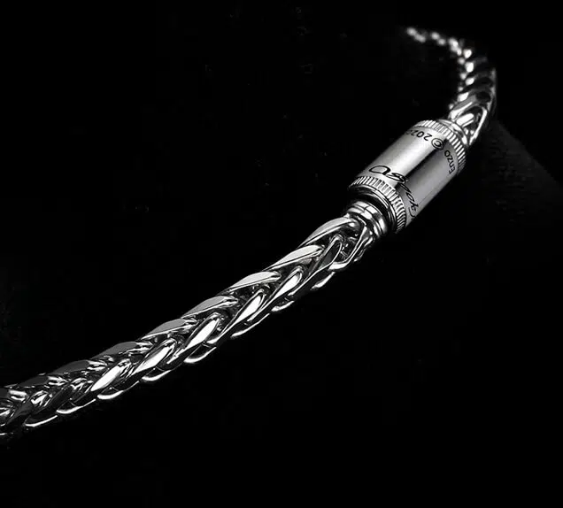 A clasp of a men's platinum wheat chain necklace designed by ByEnzo Jewelry with engraving on the chain